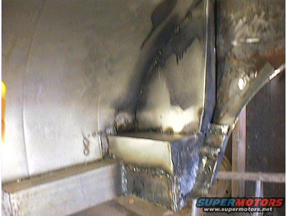 Close-up of welded metal on a car's chassis, likely during repair work