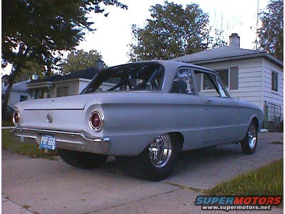 Gray 1960 Ford Falcon sedan, rear view, with roll cage and custom wheels