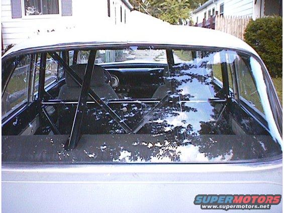 1960 Ford Falcon interior showing roll cage and bucket seats through rear window