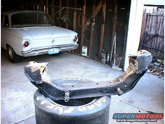1960 Ford Falcon in garage with front subframe assembly resting on a tire