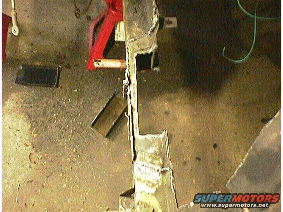 rusted metal frame on jack stands, possibly part of a car's undercarriage