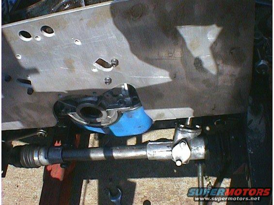 Steering rack and driveshaft assembly, metal and rubber components, partially obscured