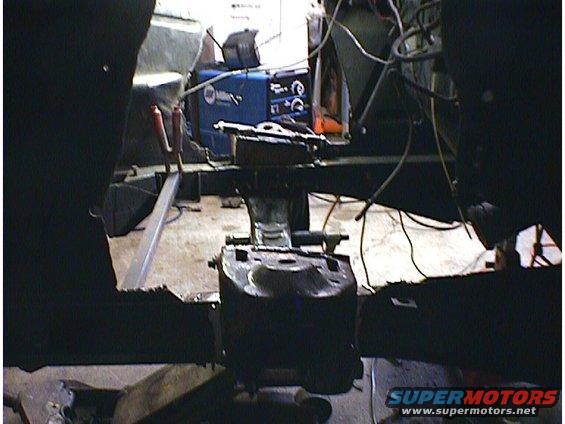 Interior of a car undergoing repairs, with a Miller welding machine in the background