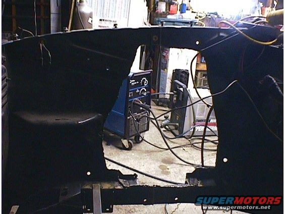 Car frame in a workshop with welding equipment in the background