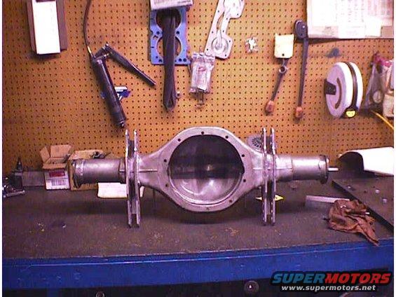 Rear axle differential on a workbench with tools on the wall