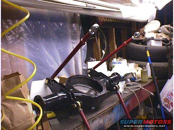 Black rear axle differential housing on a workbench with red support arms