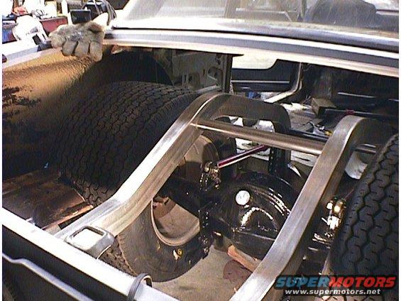 Rear axle and suspension with large tire in a car's trunk
