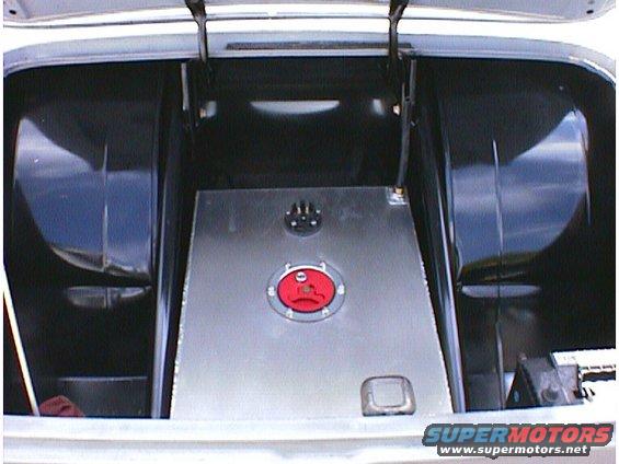 Trunk interior with a large metal fuel tank and red cap