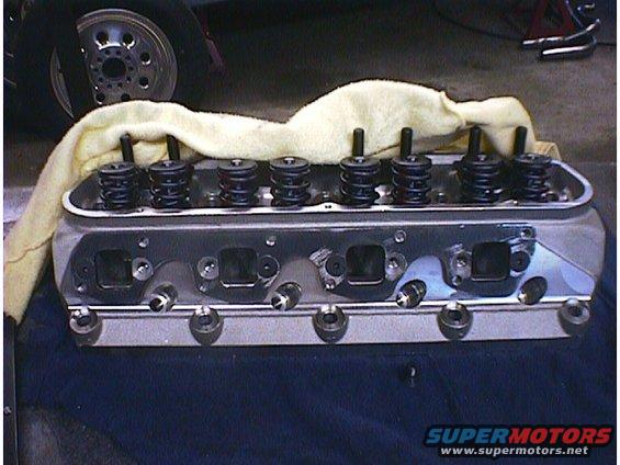 Engine cylinder head with valve springs and pushrods visible. A cloth is draped over the top