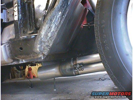 Undercarriage of a vehicle with dual exhaust pipes and a tire visible
