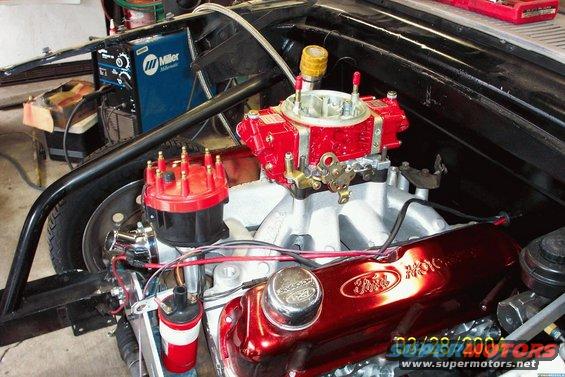 Red Ford valve covers and carburetor in engine bay