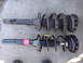 2003 Ford Taurus - Comparison of a used strut assembly and a new one, likely for a vehicle's suspension system.