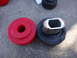 2003 Ford Taurus - Two automotive bushings, one red and one black, are shown on a concrete surface.