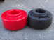 2003 Ford Taurus - A new red strut bushing is shown next to an old, worn-out black strut bushing.