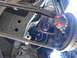 2003 Ford Taurus - Close-up of automotive suspension parts, including a brake rotor and linkage, viewed from below.