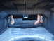 2003 Ford Taurus - Hands are seen working inside the trunk of a car with the rear seats folded down.