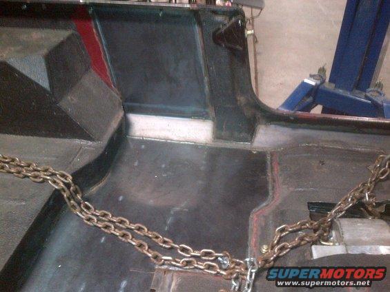 1985 Jeep CJ7 interior floor showing seat mounts and chains. Red accent on the side panel