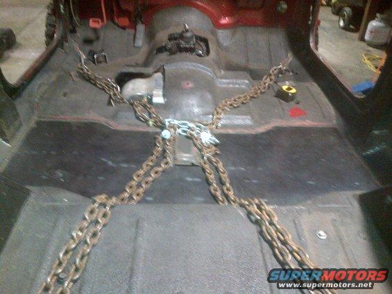vehicle interior with floor removed and chains attached to frame