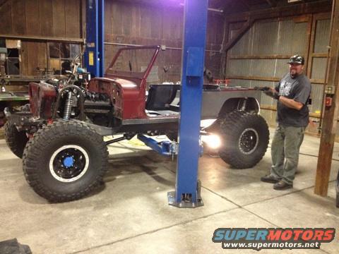 Jeep CJ body on lift, missing engine and front clip, with large off-road tires
