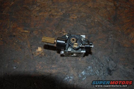 carburetor with brass fitting on a workbench