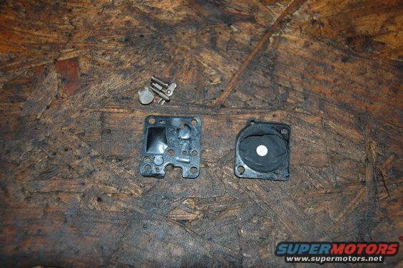 carburetor diaphragm and gasket parts on a wooden surface
