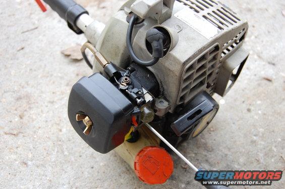 Close-up of a string trimmer engine's carburetor and air filter housing