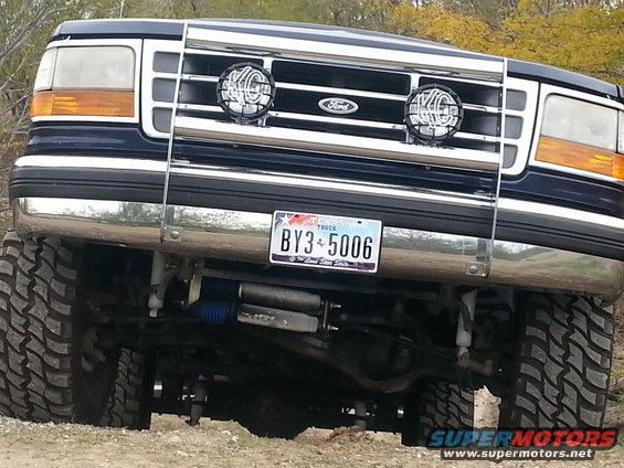 Front view of a lifted Ford F-250 truck with a brush guard and KC lights. Texas license plate BY3-5006 visible