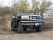 1995 Ford Bronco - This lifted 1995 Ford Bronco is shown off-road, large tires and auxiliary lights on the grille.