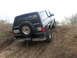1995 Ford Bronco - This Ford Bronco is navigating a challenging off-road terrain, with its rear facing the camera.