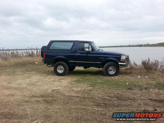 1995 Ford Bronco side view, dark blue, parked by water