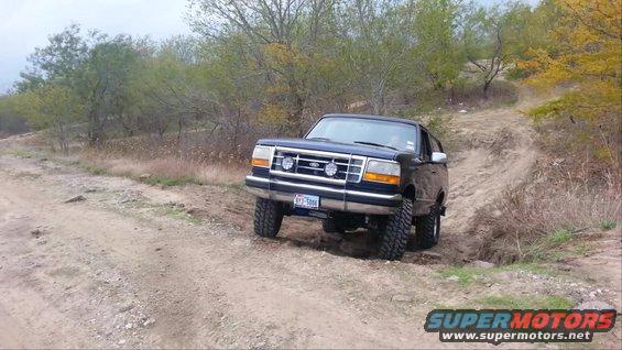 Black 1995 Ford Bronco on a dirt trail, going uphill