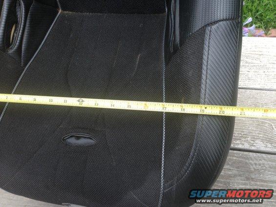 Close-up of a black car seat with a yellow measuring tape across it