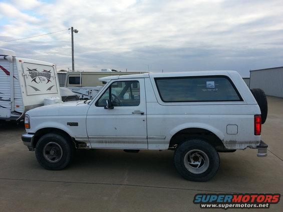 White 1996 Ford Bronco parked next to a trailer