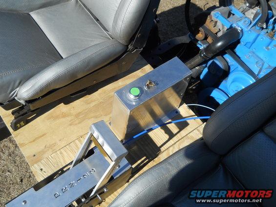 Vehicle interior with gray seats, a chrome shifter labeled P-R-N-D-3, and a blue engine block visible