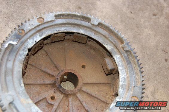 rusted flywheel with gear teeth around the edge and a central hub