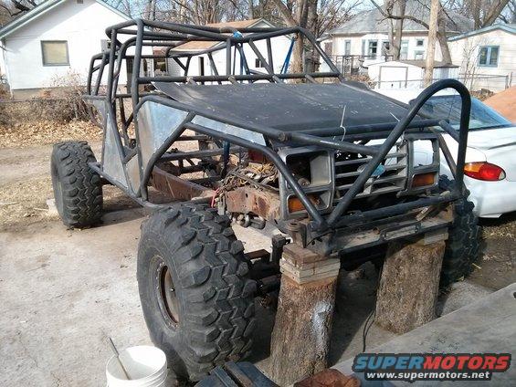 Custom buggy build with large tires and roll cage, front end appears to be from an older truck