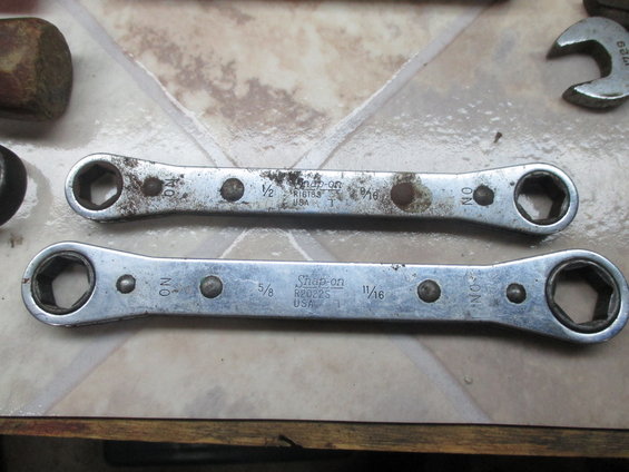 Two Snap-on ratcheting wrenches, one 1/2" x 9/16" and the other 5/8" x 11/16", on a tiled surface