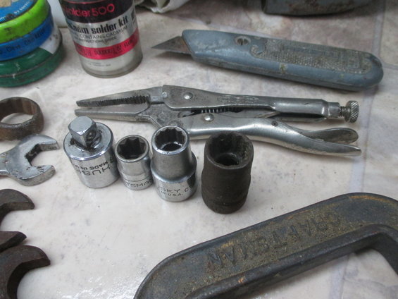 Various tools including pliers, sockets, a wrench, and a utility knife