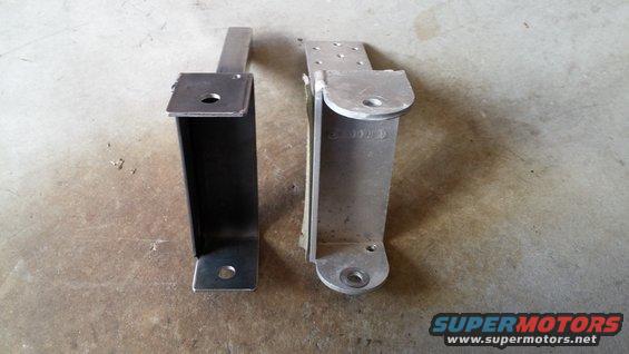 Two awning brackets, one dark metal, one silver metal