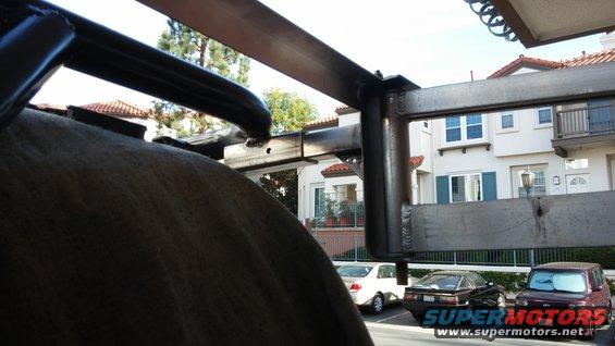 Metal awning frame over parked cars including a Toyota 4Runner