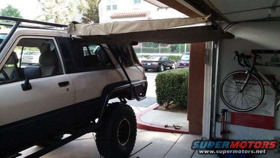 White 1985 Toyota 4Runner with large awning extended, parked in a garage