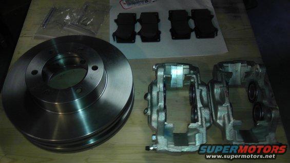 Stack of brake rotors and two brake calipers with brake pads and hardware bags