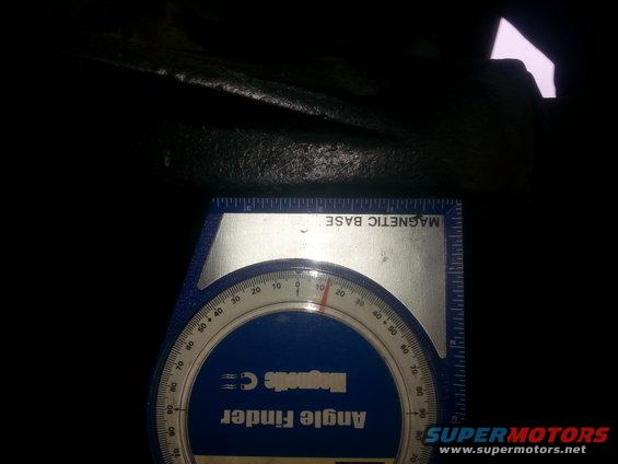 Angle finder tool with magnetic base measuring an angle on a dark, textured surface