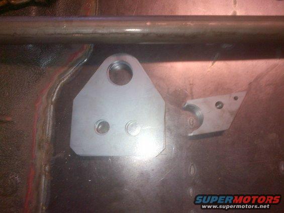Metal bracket with holes on vehicle floor