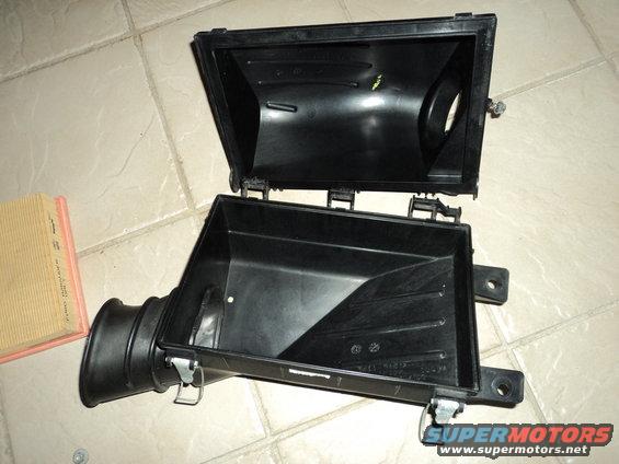 Opened air cleaner housing with a new air filter next to it
