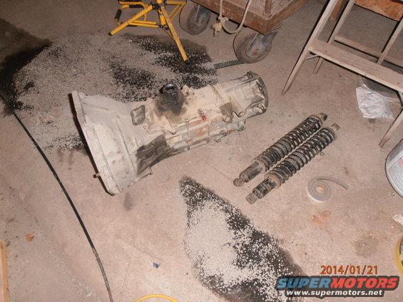 Transmission and two shock absorbers on concrete floor