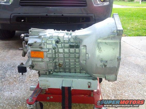 Transmission on a red stand, with part of a gray SUV in the background