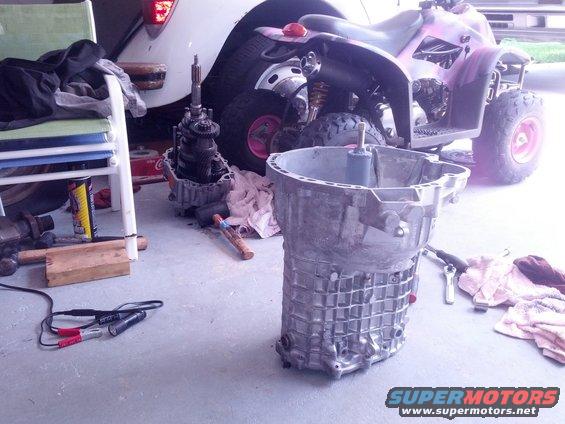 Aluminum transmission casing and gearbox on a concrete floor with an ATV in the background