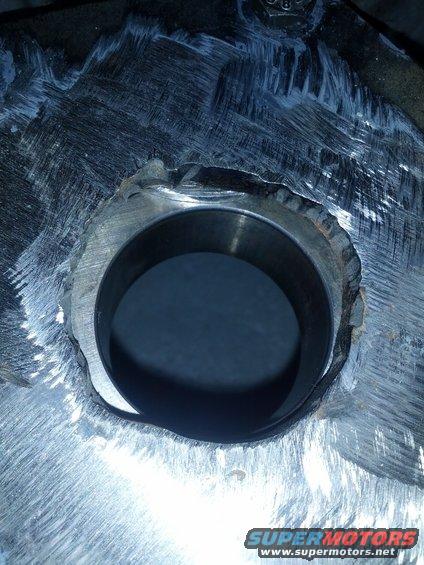 Close-up of a rough metal component with a circular opening and tool marks