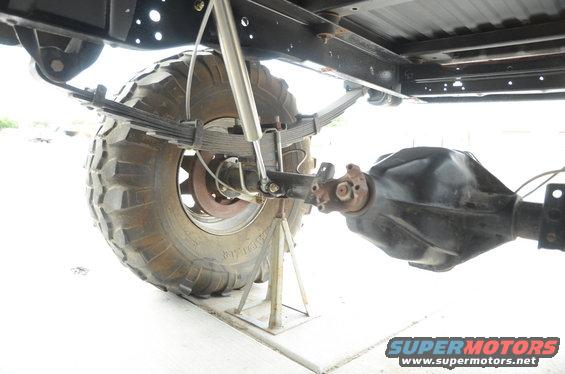 rear axle, leaf springs, and shock absorber on a vehicle supported by jack stands